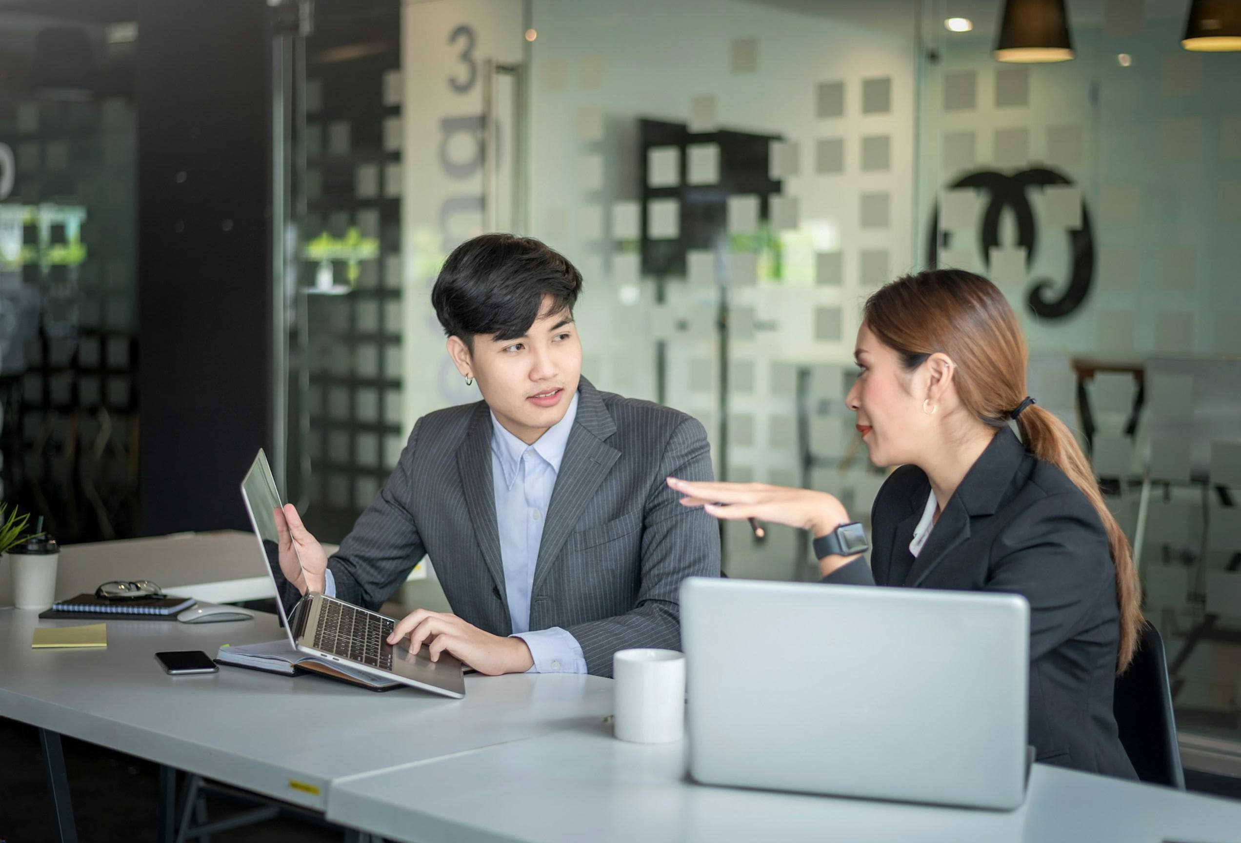 An immigration consultant reviewing a case with a client at a desk
