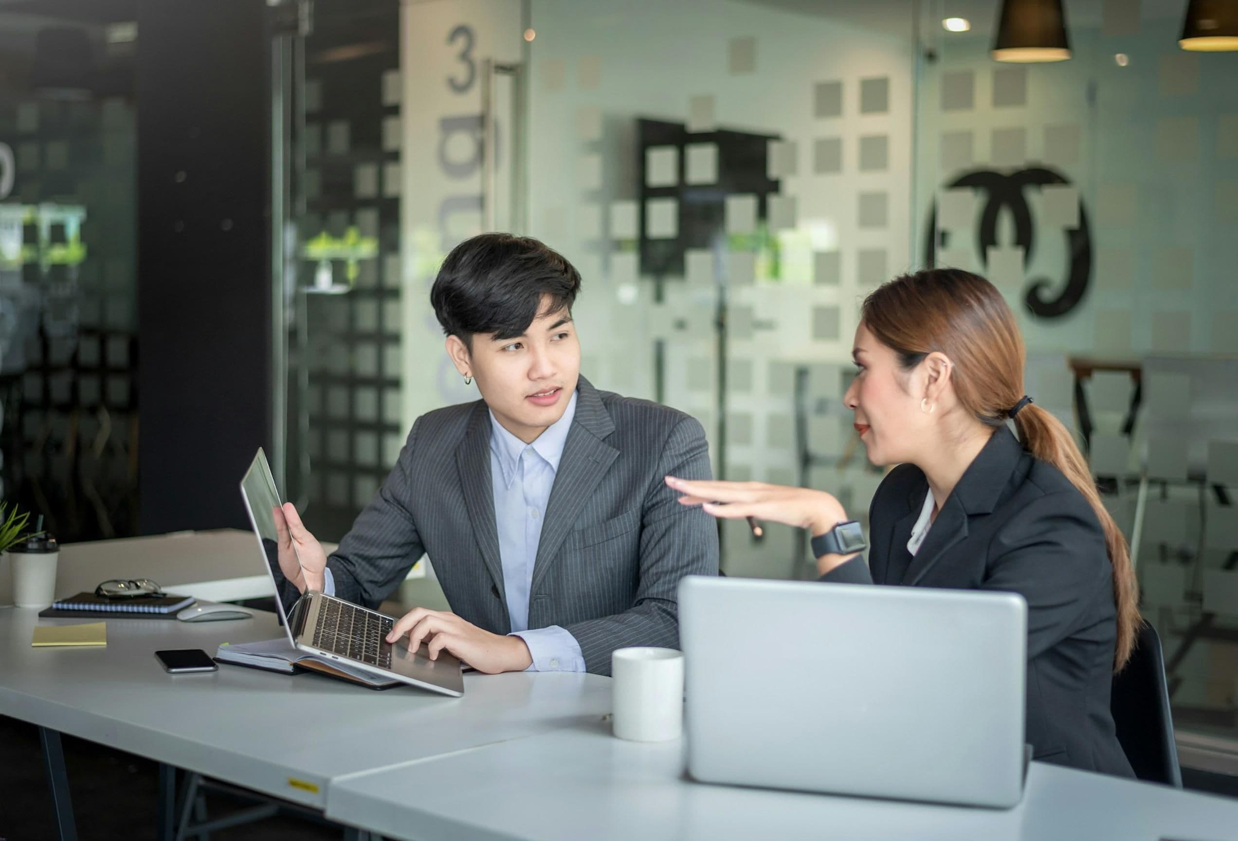 An immigration consultant reviewing a case with a client at a desk